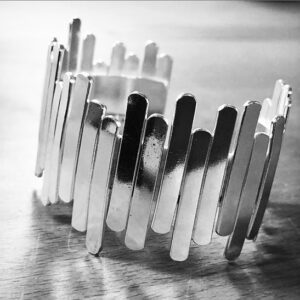 A handmade silver bracelet shaped as sticks put together randomly