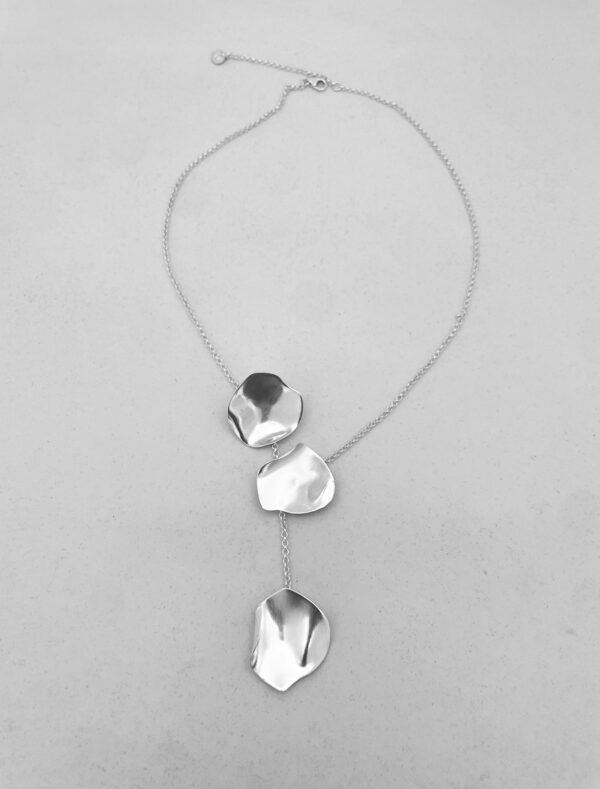 A silver necklaces with three silver rose petals.