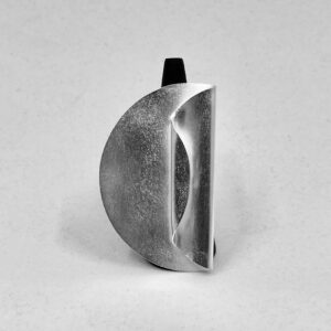 A ring holder with a matte silver ring shaped as a big coin with one side folded