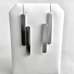 Two handmade silver earrings shaped as two flat sticks unsymetrically attached to each other.