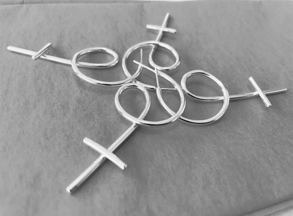 Four silver earrings shaped as venus symbols