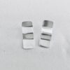 A pair of silver earrings shaped as wavy rectangles