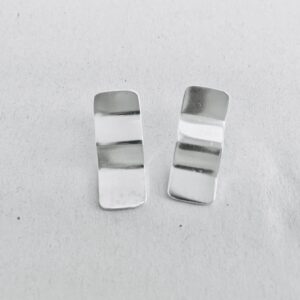 A pair of silver earrings shaped as wavy rectangles