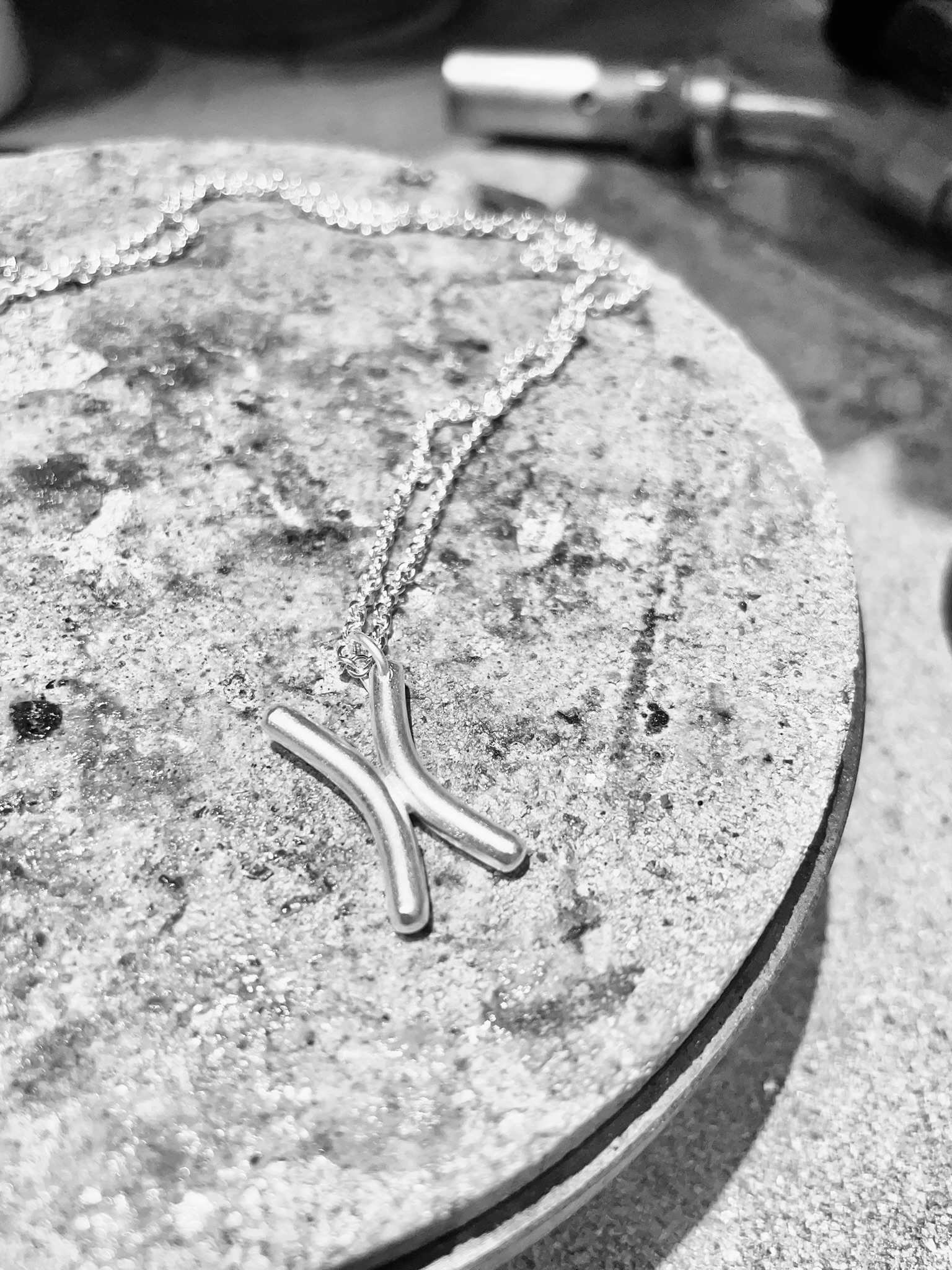 A silver chromosome necklace on a silversmith's bench